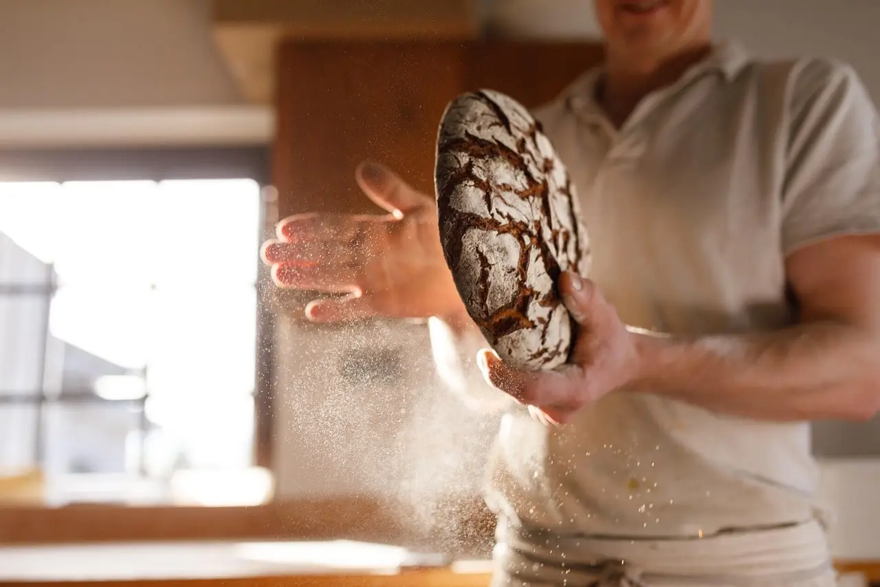artisan boulanger qui façonne du pain